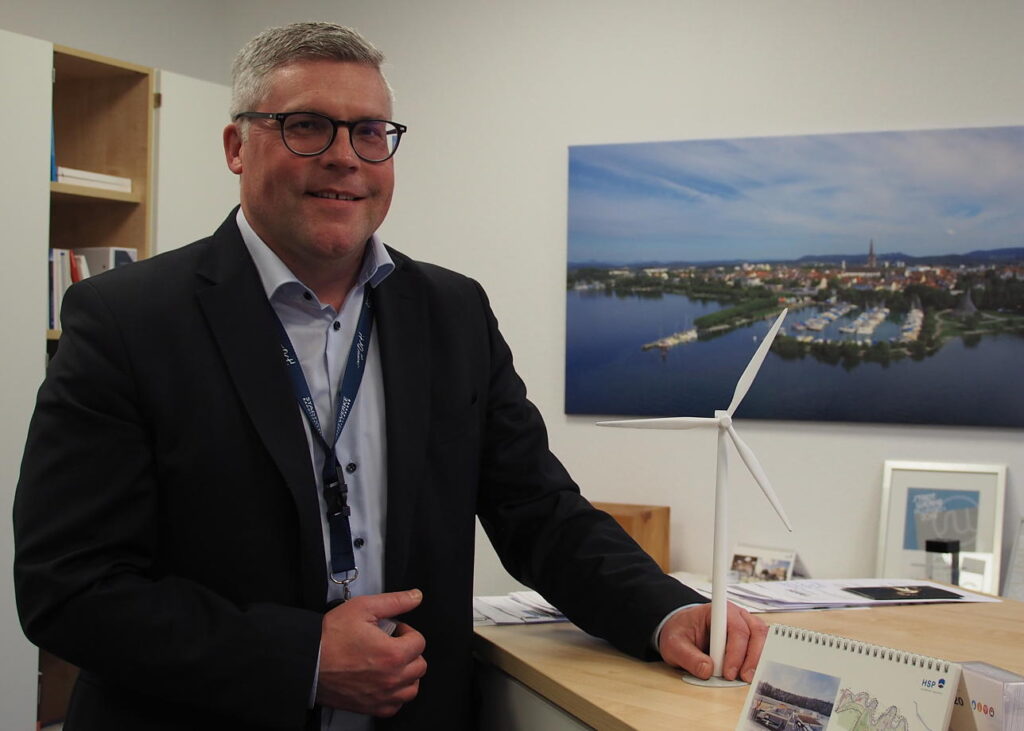 Hegauwind-Geschäftsführer Andreas Reinhardt in seinem Büro bei den Stadtwerken Radolfzell mit einem Miniatur-Windrad. Sollten bei Watterdingen drei weitere Anlagen gebaut werden dürfen, wäre laut Reinhardt deren Ertrag durch technischen Fortschritt deutlich höher als in Verenafohren. Bild: gtr | Bild: Trautmann, Gudrun